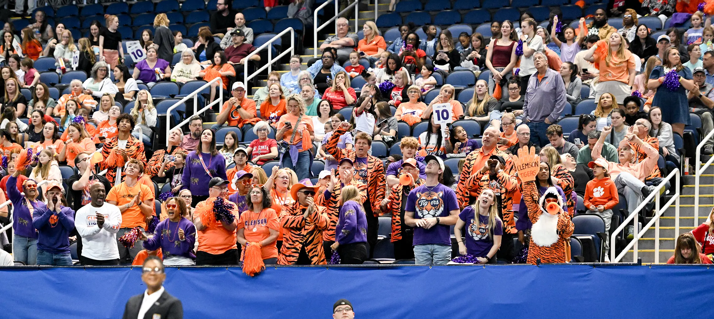Fans in team colors filling the stands at a championship in the Greensboro Coliseum Complex